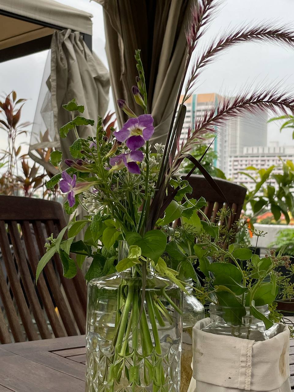 Flower arrangement in a glass bottle, featuring locally grown flowers from the Cream of the Crop flowers subscription.